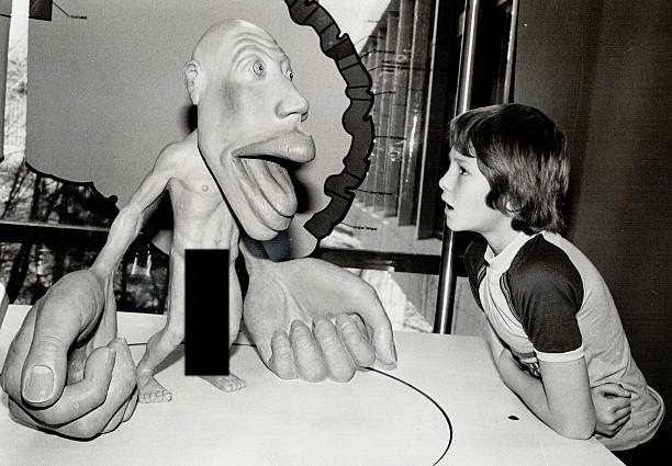 a child stares in horror at a model of a cortical homunculus